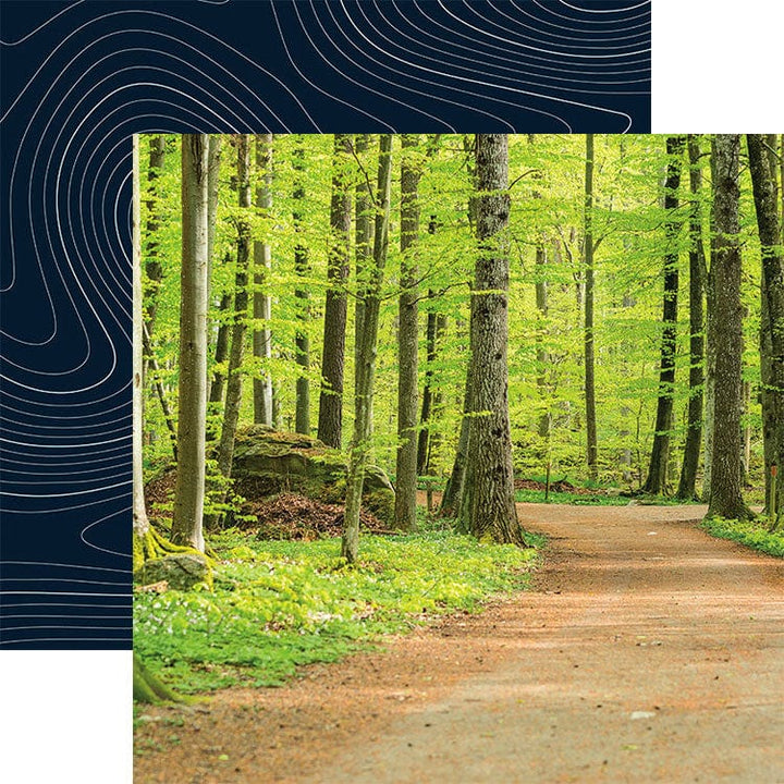 scrapbook paper featuring a photographic image of a path in the woods, shown overlapping a pattern of white wavy lines on a dark blue background.
