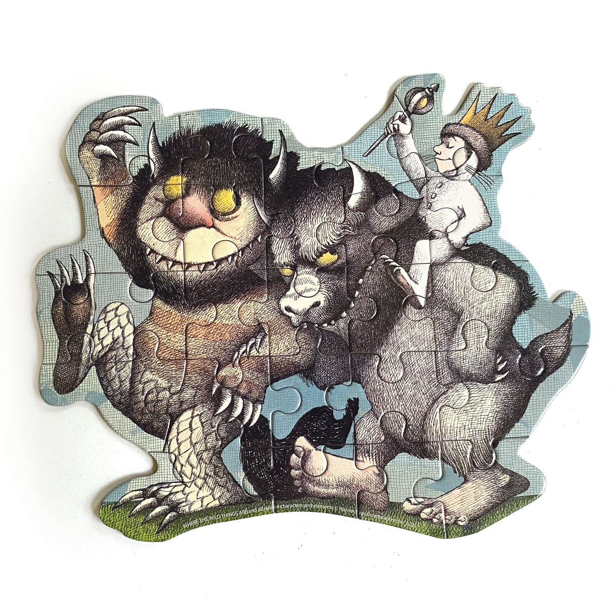 PUZ-7022E - Mini Jigsaw Puzzle - Where The Wild Things Are - Shaped puzzle featuring illustrated wild creatures with horns and a crowned child character against a light blue background