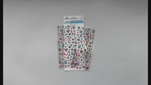Female hands pick up and show front and back details of mini stickers featuring dream catchers, feathers and directional arrows.