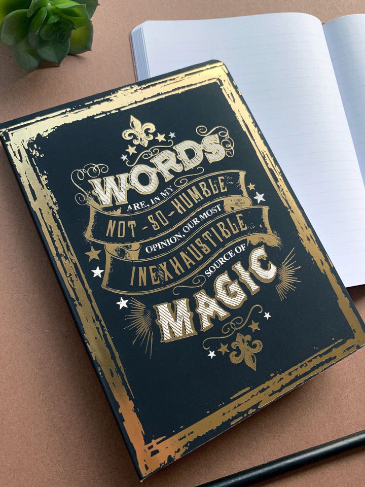 Harry Potter softcover journal notebook shown laying on a desk. Journal cover features the quote, "Words are, in my not-so-humble opionion, our most inexhaustible source of magic" on a black background.