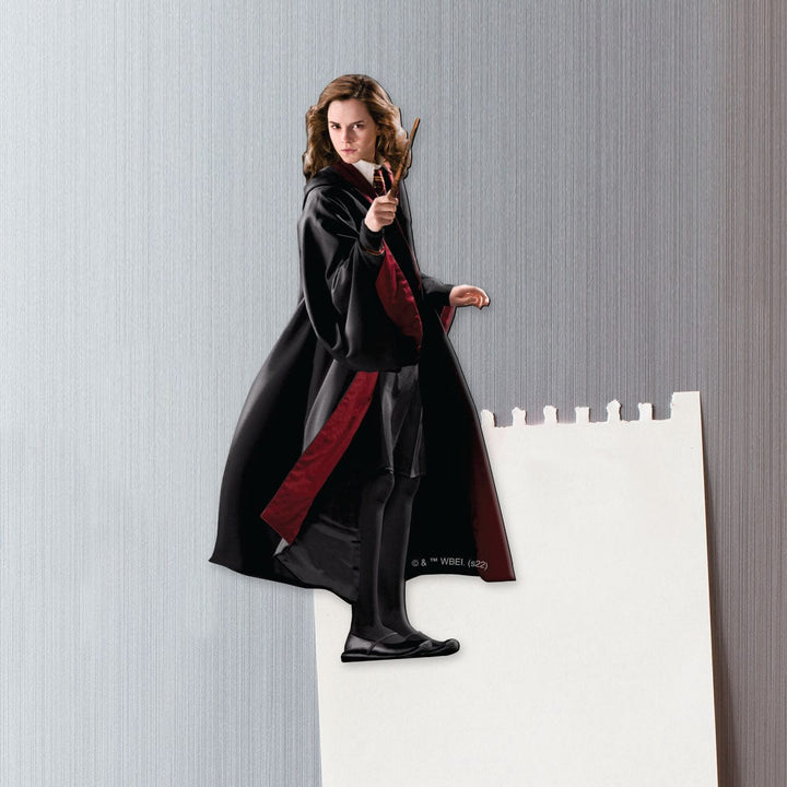 fridge magnet featuring Hermoine practicing witchcraft shown on a metal background attached to a torn sheet of white memo paper.